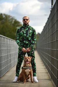 Portrait of dog wearing sunglasses on footbridge