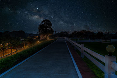 Railroad tracks against sky at night