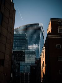 Low angle view of modern buildings against blue sky