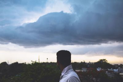 Rear view of man standing against sky during sunset