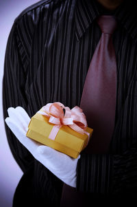 Midsection of man holding gift box