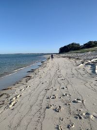 Scenic view of beach against clear blue sky