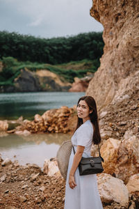 Side view portrait of woman standing by rocks