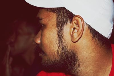 Close-up of man wearing cap looking away