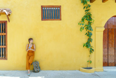 Rear view of woman standing against wall