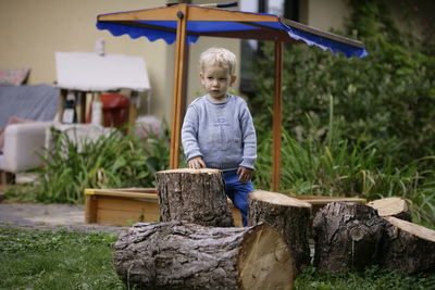 Portrait of young woman sitting on wood