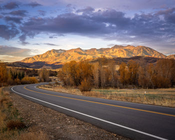 Road by mountains against sky