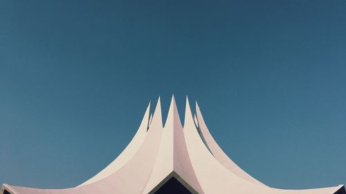 Low angle view of airplane against clear blue sky