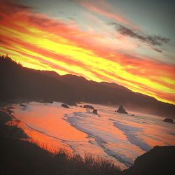 Scenic view of dramatic sky over silhouette landscape