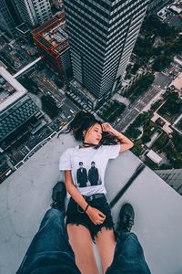 High angle view of woman using mobile phone while sitting in city