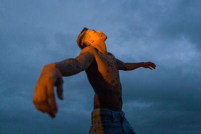 Low angle view of shirtless man against sky