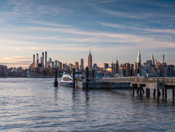 Sunset over east river midtown manhattan skyline and north 5th street pier at brooklyn