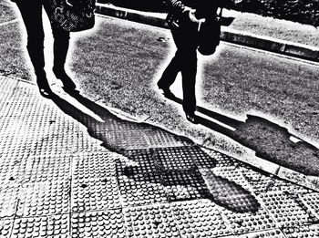 Low section of woman standing on footpath