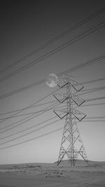 Low angle view of electricity pylon on land against sky