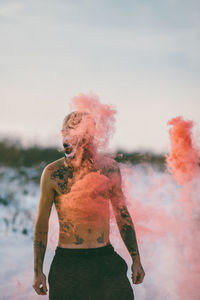 Close-up of shirtless man in smoke