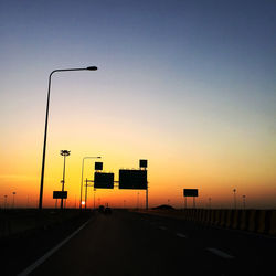Street lights against sky during sunset