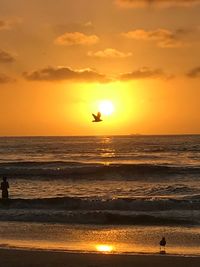 Scenic view of sea against orange sky