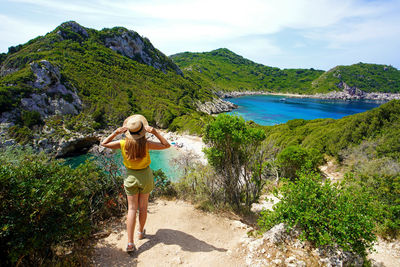 Tourism in greece. female hiker looking amazing landscape of porto timoni on corfu island, greece.