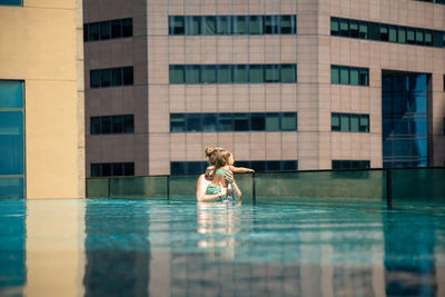 Full length of woman on swimming pool against building