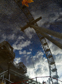 Low angle view of building in puddle against sky