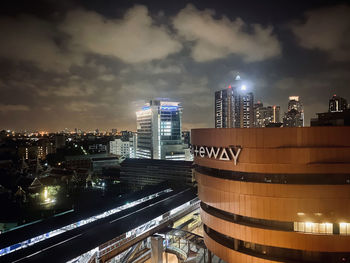 Illuminated buildings in city against sky at night