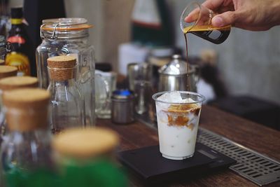 Cropped hand of barista preparing coffee in cafe