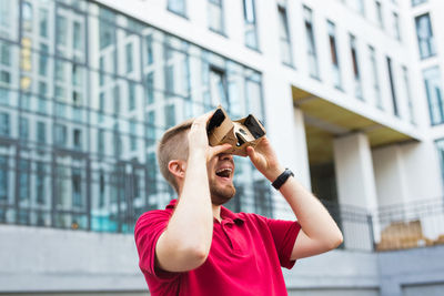 Man wearing virtual reality headset while standing outdoors