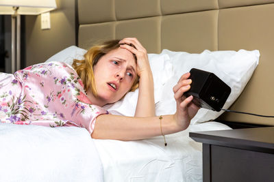 Portrait of woman lying on bed at home
