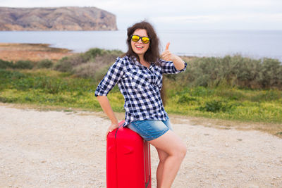 Portrait of young woman wearing sunglasses standing outdoors