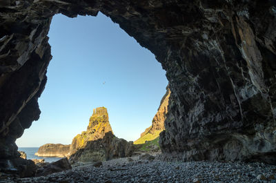 Low angle view of rock formations in sea against sky