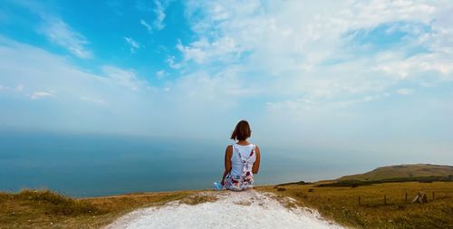 Rear view of woman on shore against sky