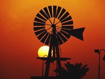 Silhouette traditional windmill against clear orange sky