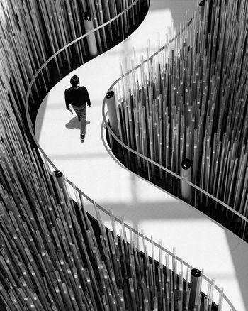 HIGH ANGLE VIEW OF MAN MOVING ON STAIRCASE IN CITY