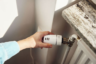 Woman adjusting radiator temperature