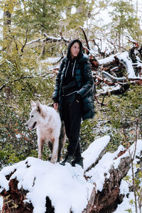 Portrait of woman standing on snow covered field