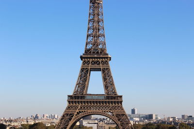 Communications tower in city against blue sky