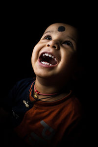 Portrait of baby boy against black background