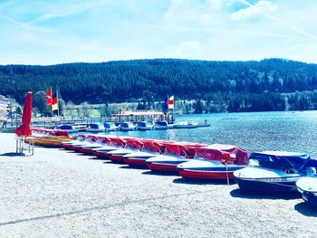 Boats moored on lake against sky