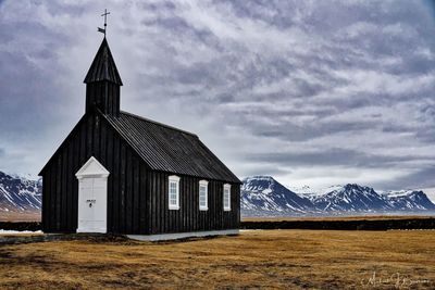 Built structure on snowcapped mountain against sky