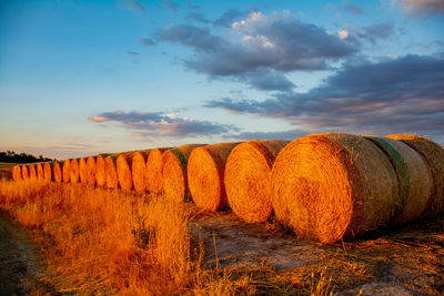 Hay bales on field against sky