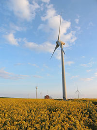 Windmills on field against sky