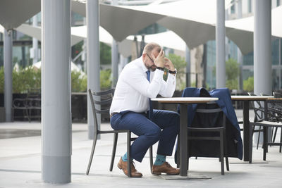 Full length of man sitting on chair at table