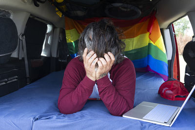 Rear view of boy using digital tablet while sitting in car