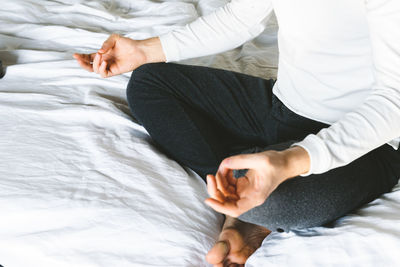 Midsection of woman lying on bed