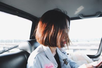 Rear view of woman sitting in car