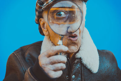 Portrait of man making face against blue background