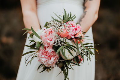 Close-up of woman holding pink rose flower