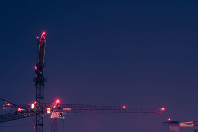 Illuminated communications tower against sky at night