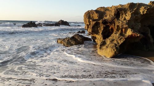 Rocks on beach against sky