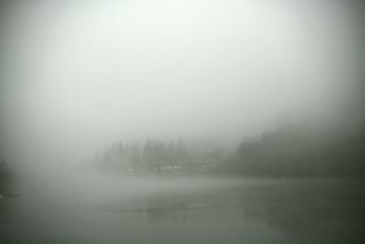 Scenic view of lake against sky during foggy weather